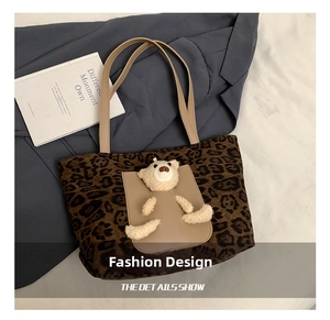 Detail showing plush 3D bear on leopard print tote bag with soft suede texture