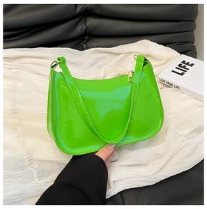Close-up of vibrant neon green patent leather shoulder bag with gold zipper and strap