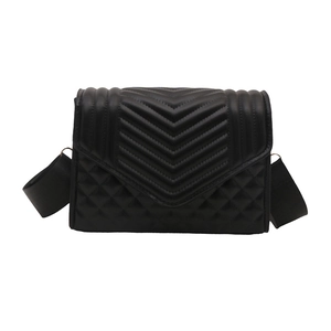 Black quilted crossbody bag with diamond patterns and a wide fabric shoulder strap