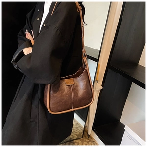 Side view of dark brown faux leather shoulder bag with embossed fashion text detail