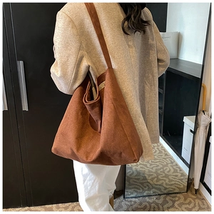 Brown faux suede tote bag shown on model featuring large capacity and soft texture