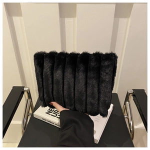 Gros plan du sac à main en fausse fourrure noire avec plis élégants et texture douce