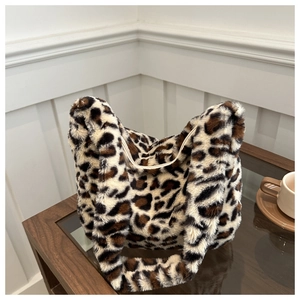 Détail du sac cabas en fausse fourrure léopard posé sur une table basse en bois