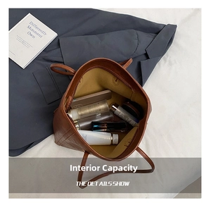 Spacious interior of a brown matte leather tote bag with functional pockets and daily items