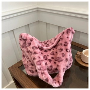 Détail de la texture en fausse fourrure léopard rose sur un grand sac hobo d'automne