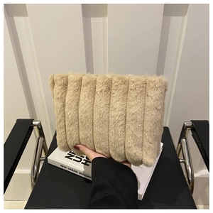 Détail de la texture en peluche douce et du plissé rayé du sac en fausse fourrure beige
