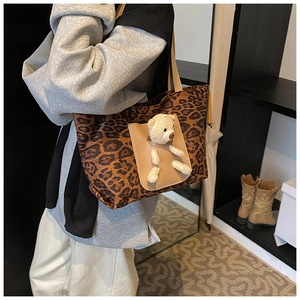Détail du cabas léopard avec breloque d'ours en peluche et poche avant beige pour femmes