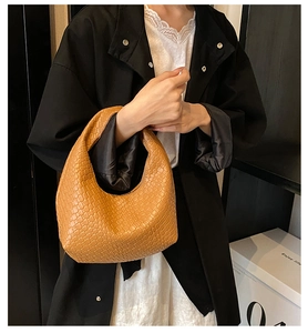 Detail of camel brown woven hobo handbag showing texture and minimalist leather craft