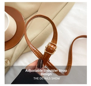 Détail de la bandoulière réglable en cuir marron avec boucle dorée pour sac rétro