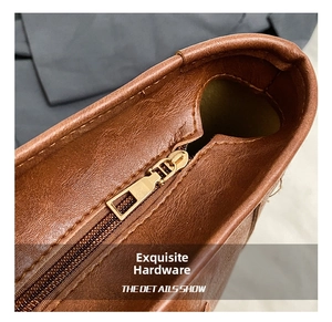 Close-up of golden metal zipper and grain leather texture on brown shoulder bag