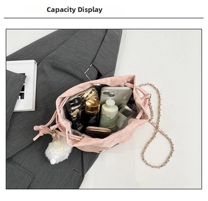 Pink drawstring bucket bag with chain strap showing interior capacity and soft pompom charm