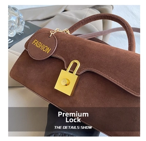 Dettaglio borsa scamosciata marrone con chiusura girevole oro e targhetta fashion