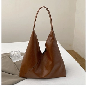 Detail view of large caramel brown hobo bag showing fine leather texture and stitching