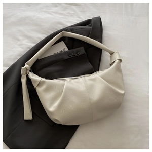 Dettaglio borsa hobo crema in pelle martellata con pieghe e tracolla con nodo decorativo