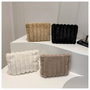 Détail de quatre sacs à main en peluche rayée en beige, noir, blanc et marron