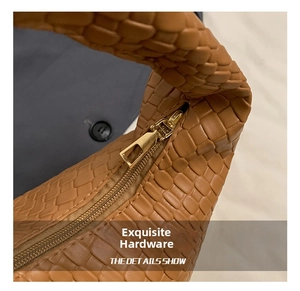 Detailed macro shot of premium golden zipper and brown woven leather texture on handbag