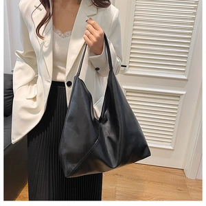 Close-up of black leather tote bag with soft matte texture and natural drape effect