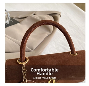 Dettaglio della borsa vintage in pelle scamosciata marrone con anelli dorati
