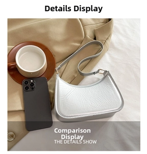 Detail view of a silver crescent-shaped shoulder bag with smooth metallic leather texture