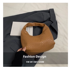 Detailed close-up of brown woven leather texture on a hobo style shoulder bag
