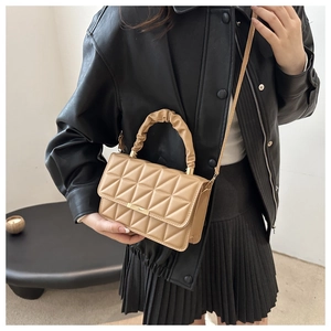 Detail showing khaki quilted texture with golden metal buckle and ruched handle