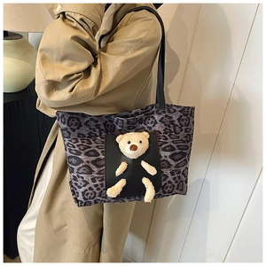Détail du cabas imprimé léopard avec ours en peluche 3D et bandoulière en cuir noir