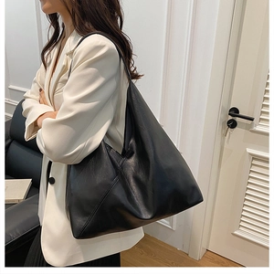 Detail of minimalist black matte leather tote bag with unique diagonal stitching detail