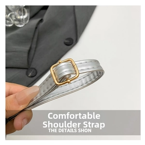 Detail of silver shoulder strap with white stitching and gold adjustable metal buckle