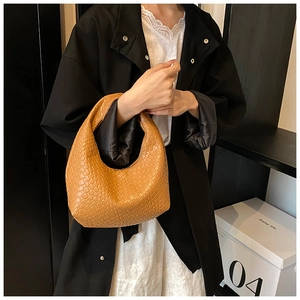 Detailed texture of brown woven hobo shoulder bag styled with fashionable outfit