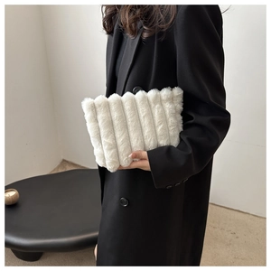 Detail einer weichen weißen Kunstpelz-Clutch mit vertikaler Streifentextur von einem Model