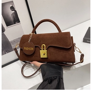 Dettaglio borsa in pelle scamosciata marrone scuro con lucchetto dorato e ciondolo