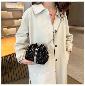Detail of black sequin bucket bag with silver chain strap and pearl drawstring accents