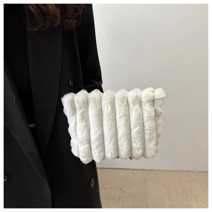 Detail of white faux fur clutch with vertical textures and gold zipper on black coat