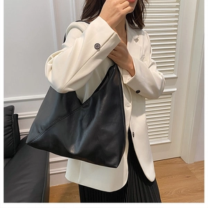 Detail showing the large capacity and soft leather texture of this minimalist black tote bag