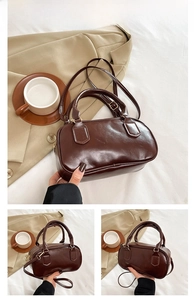 Detail of coffee brown Boston bag with glossy finish and adjustable shoulder strap