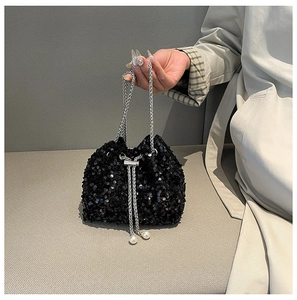 Close-up of black sequined bucket bag with silver chain and elegant pearl charms