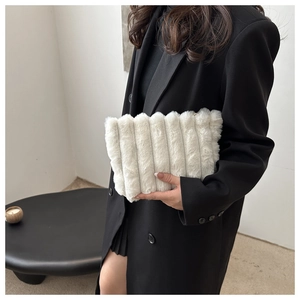 Détail d'une pochette en fausse fourrure blanche avec texture matelassée verticale douce