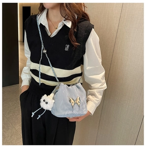 Detailed view of light blue drawstring bucket bag with silver butterfly and plush charm