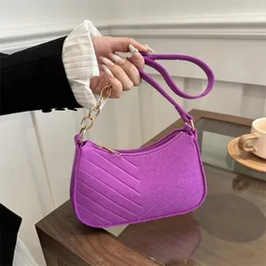 Detail der lila gesteppten Baguette-Tasche mit goldener Kette und Leder-Schultergurt