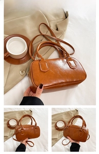 Detailed view of a brown vintage pillow bag with lychee grain texture and gold hardware