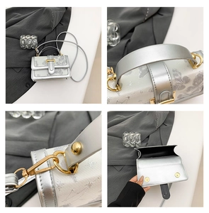 Detail view of silver mini crossbody bag showing glitter texture and butterfly embroidery