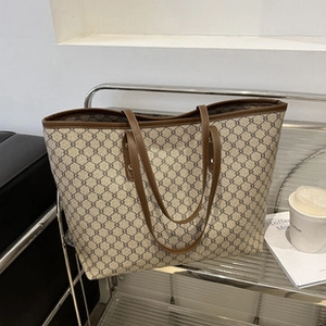 Makroaufnahme des Retro-Geometriemusters und des dunkelbraunen Ledergriffs der Shopper-Tasche