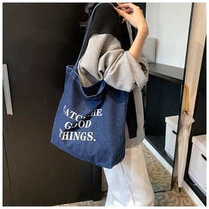 Detail of dark blue denim tote bag with Catch the good things white letter printing