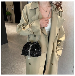 Detail of black sequined bucket bag with silver chain and large pearl charms on strap