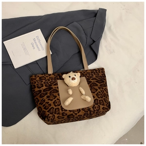 Detailed shot of leopard print tote bag with 3D teddy bear plush doll and leather straps
