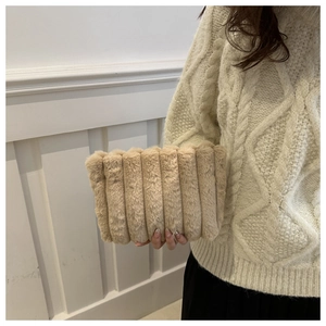 Close-up of a plush khaki faux fur clutch bag with textured vertical stripes for autumn