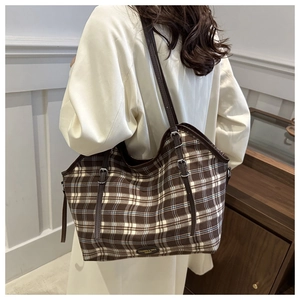 Brown vintage checkered canvas tote bag shown on model's shoulder for size reference