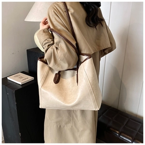 Detail of a chic tote bag with vintage beige crackle texture and brown shoulder straps