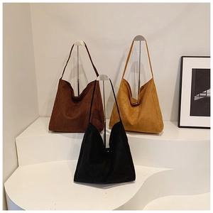 Large vintage suede tote bags in black, dark brown, and yellow on minimalist stands
