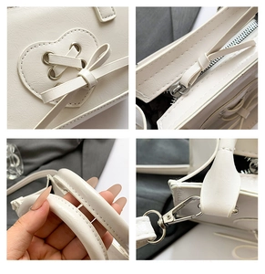 Detail of white vintage handbag showing heart patch, bow design and silver metal hardware
